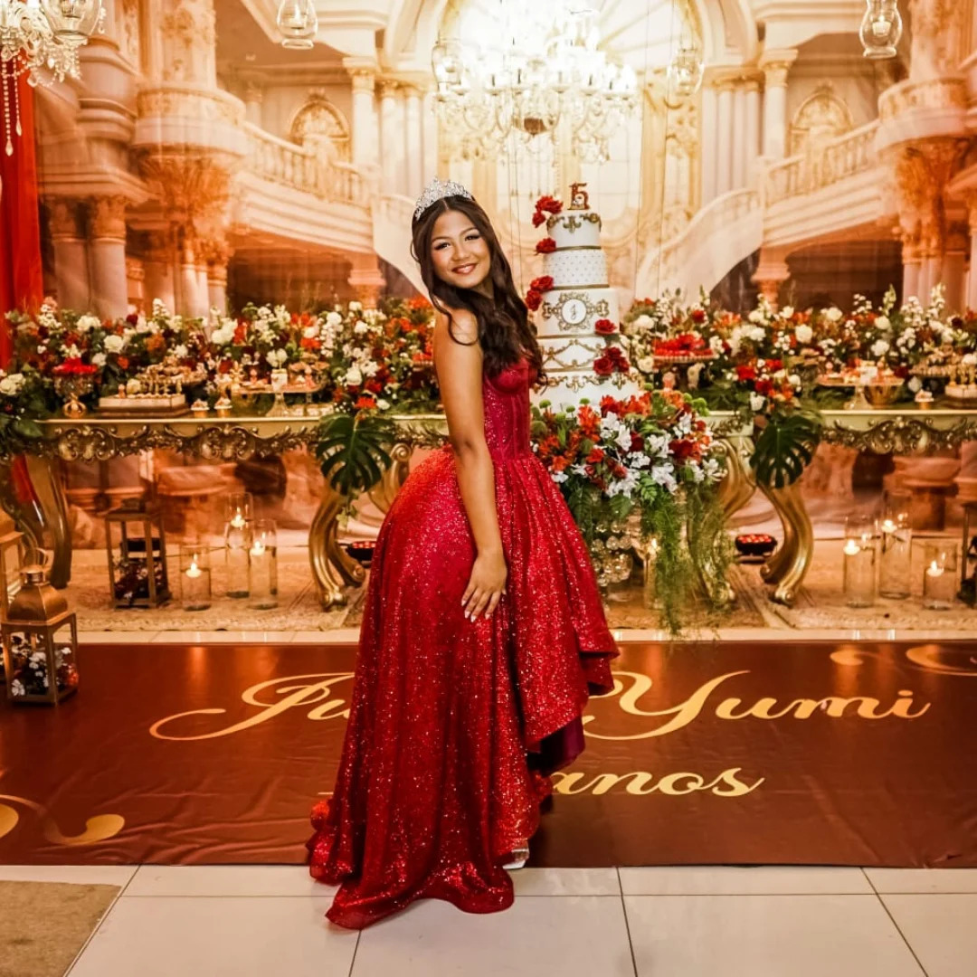 Debutante em vestido vermelho com cenário de palácio